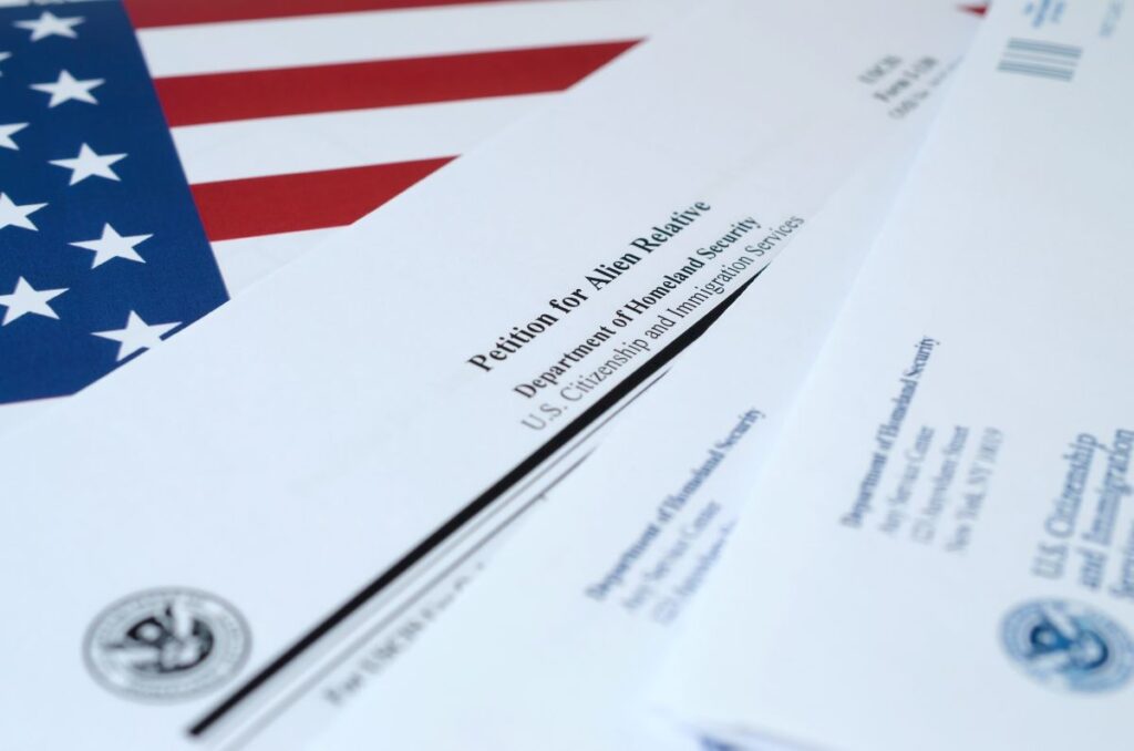 I-130 Petition for alien relative blank form lies on United States flag with envelope from Department of Homeland Security close up